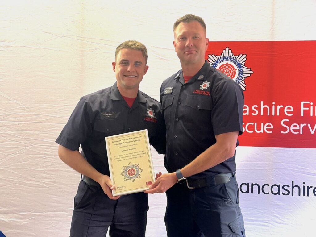Firefighter Connor Ward receives a certificate of gratitude from Area Manager Rossen